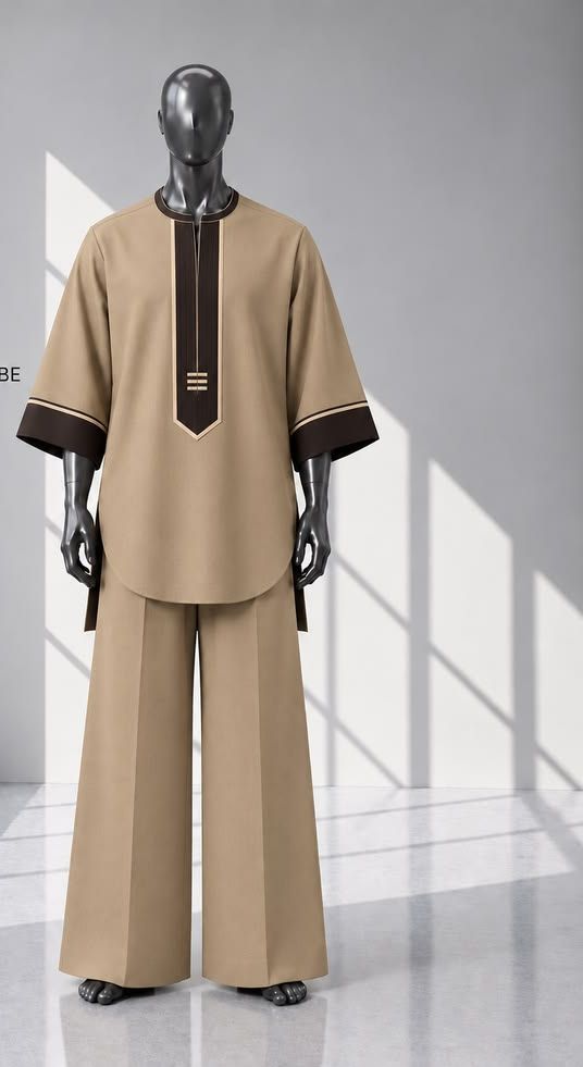 A custom-made tunic and wide trousers in tan with dark brown trim on a mannequin